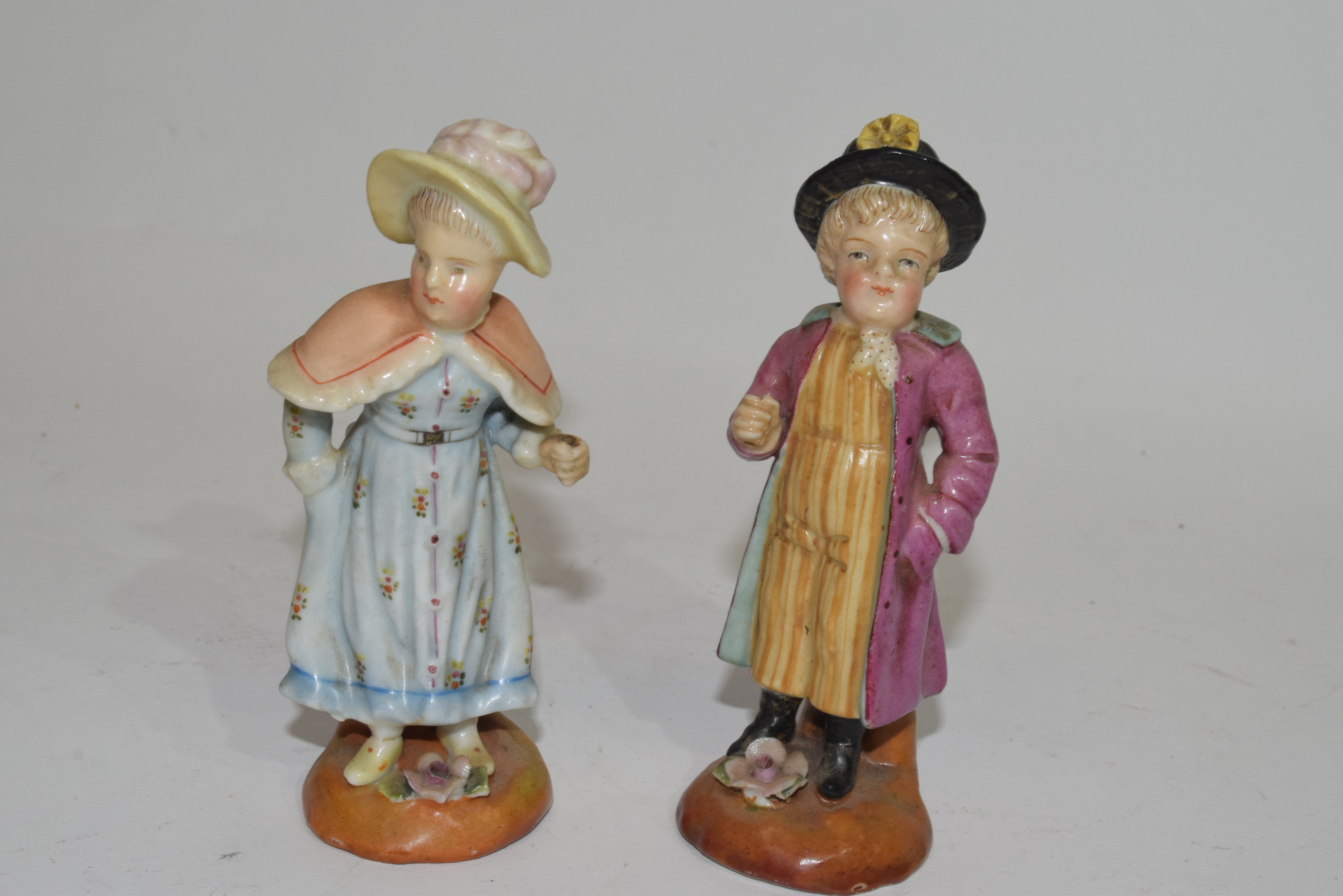 Pair of Continental porcelain figures of a boy and a girl with blue AR mark to base