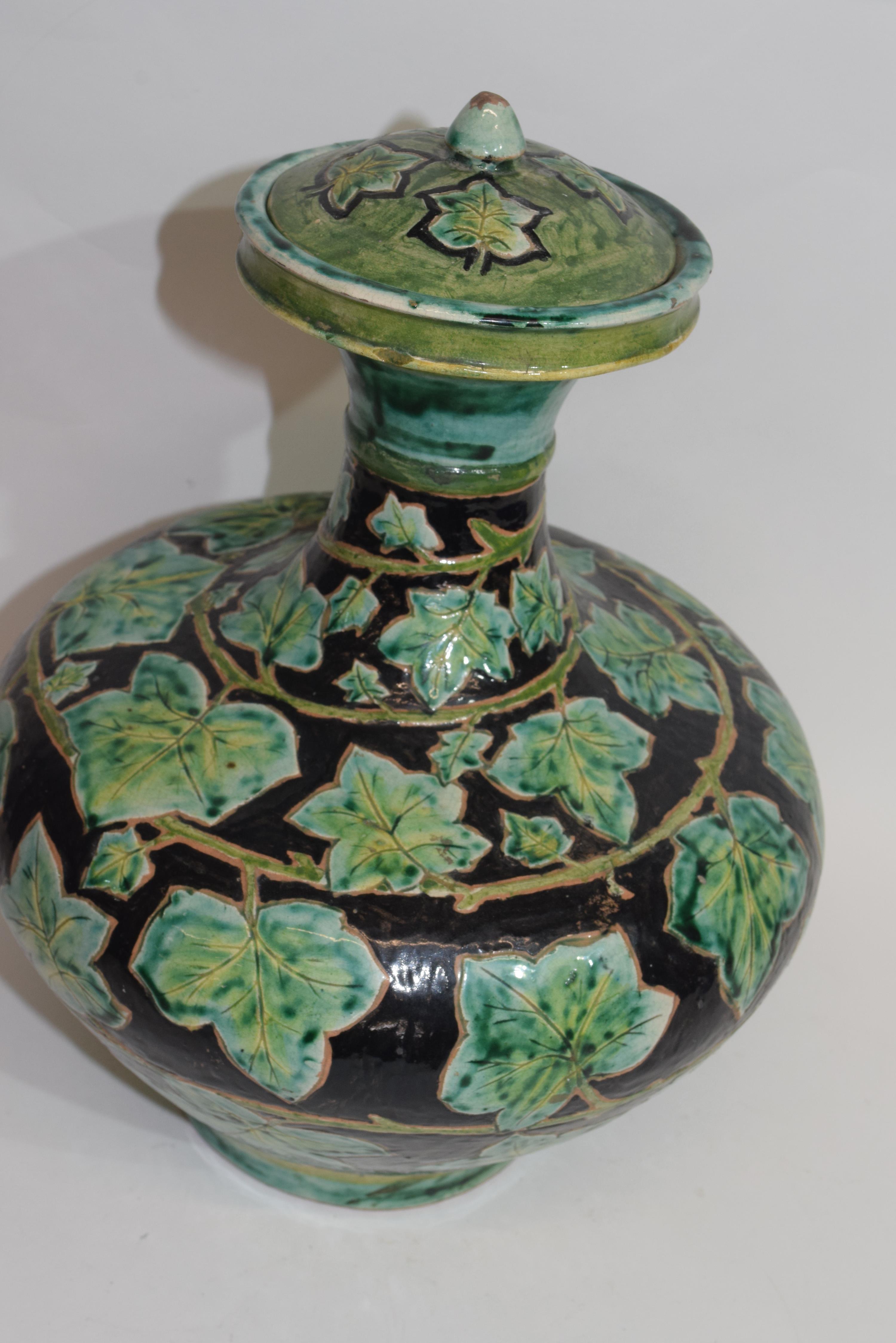 Della Robbia pottery vase, the brown ground with a green leaf decoration, factory mark to base