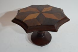 An apprentice piece, a miniature octagonal dining table, the top inlaid with specimen wood in a star