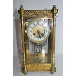 French gilt brass and four glass mounted clock, the circular white enamel face with Arabic