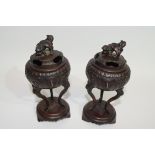 Pair of Oriental censers on oval stands, the censers raised on three elongated feet, the covers with