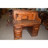 Maple & Co London and Paris, oak tambour roll front twin pedestal desk with fitted interior, the