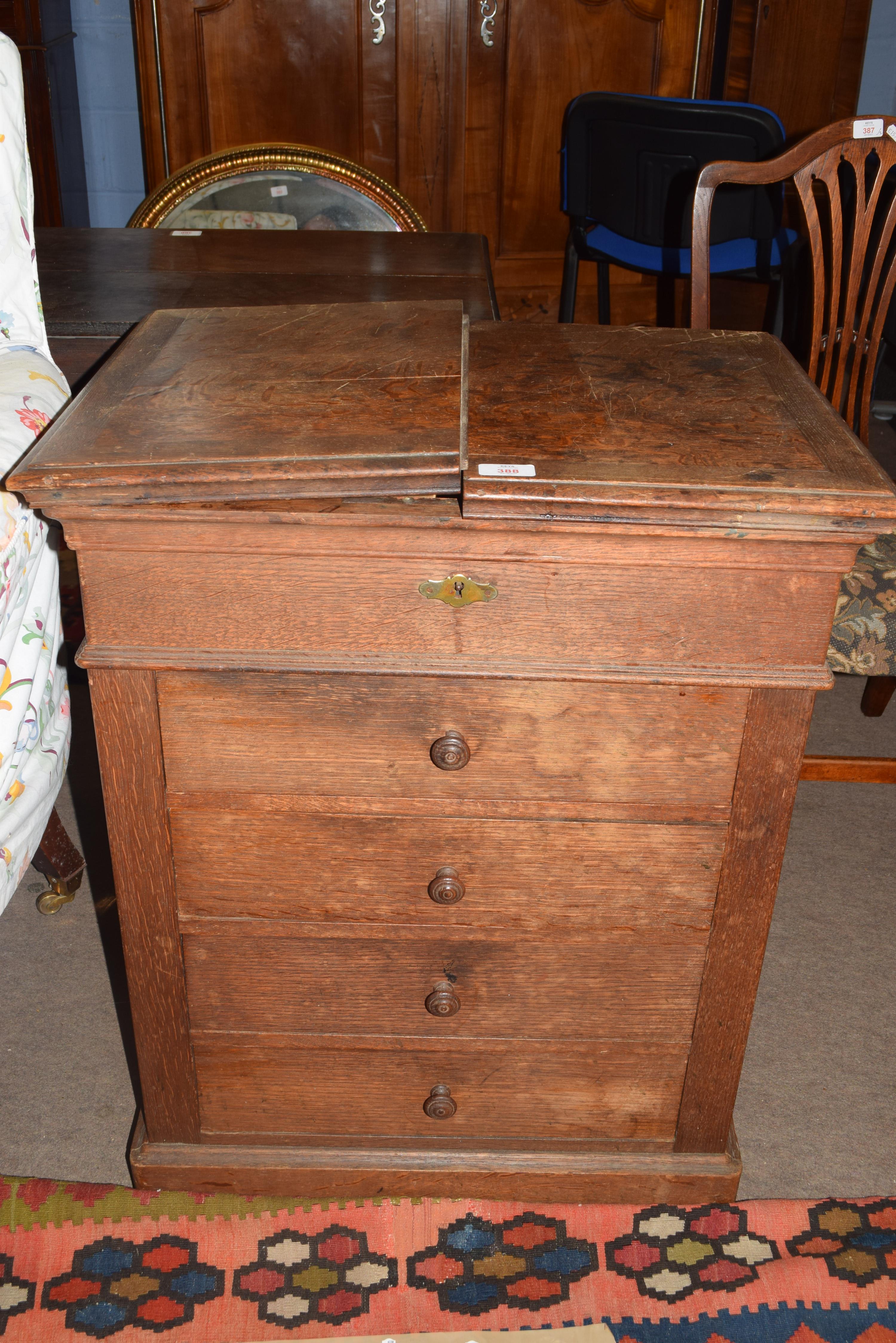 Late 19th century oak shop cabinet with fold-up lid opening to reveal an area containing mixing tub,