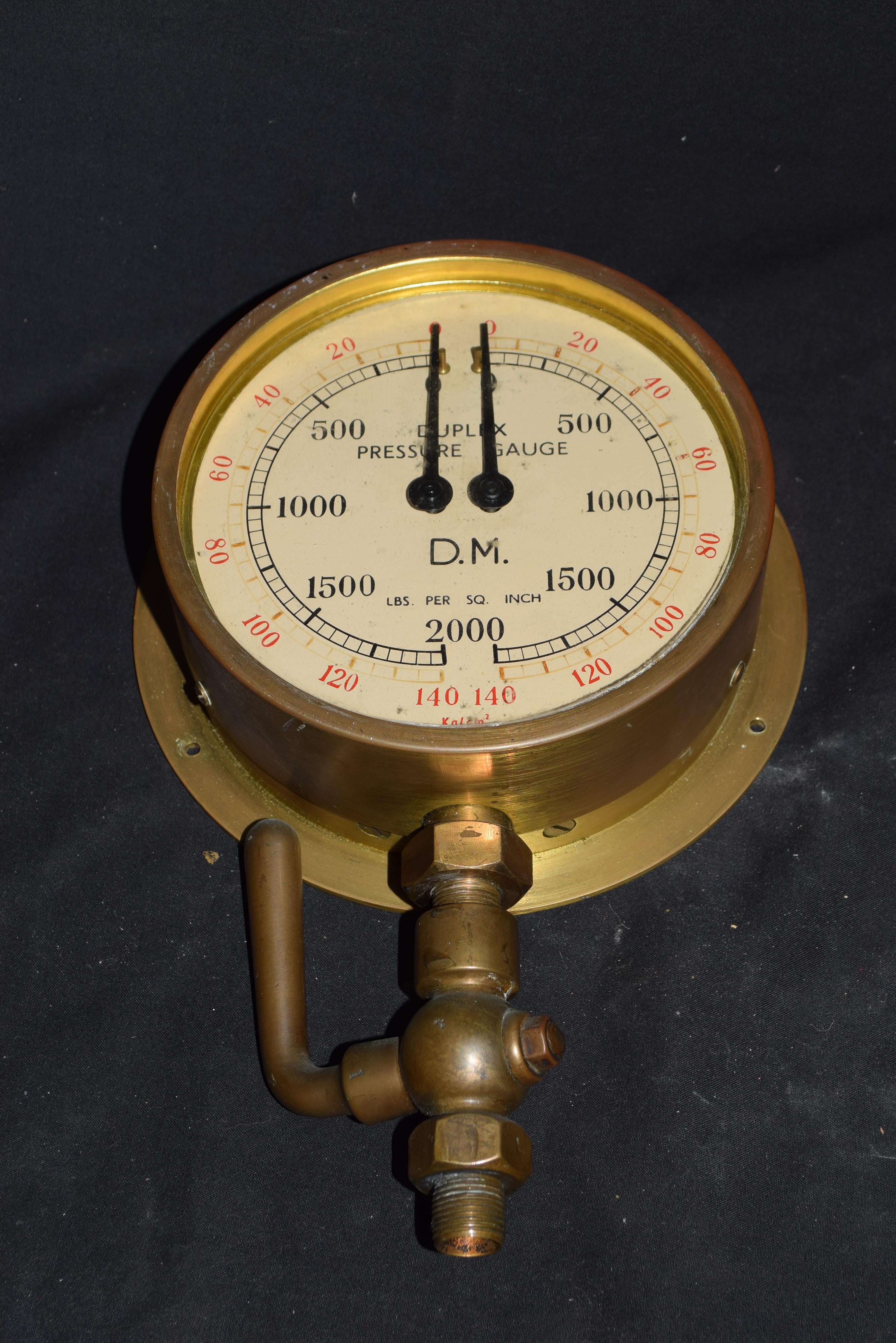 Duplex pressure gauge in circular brass case measuring pounds per square inch and kilograms per