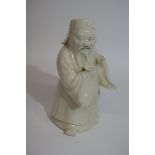 Unusual white pottery glazed figure of a Chinese deity, 15cm high