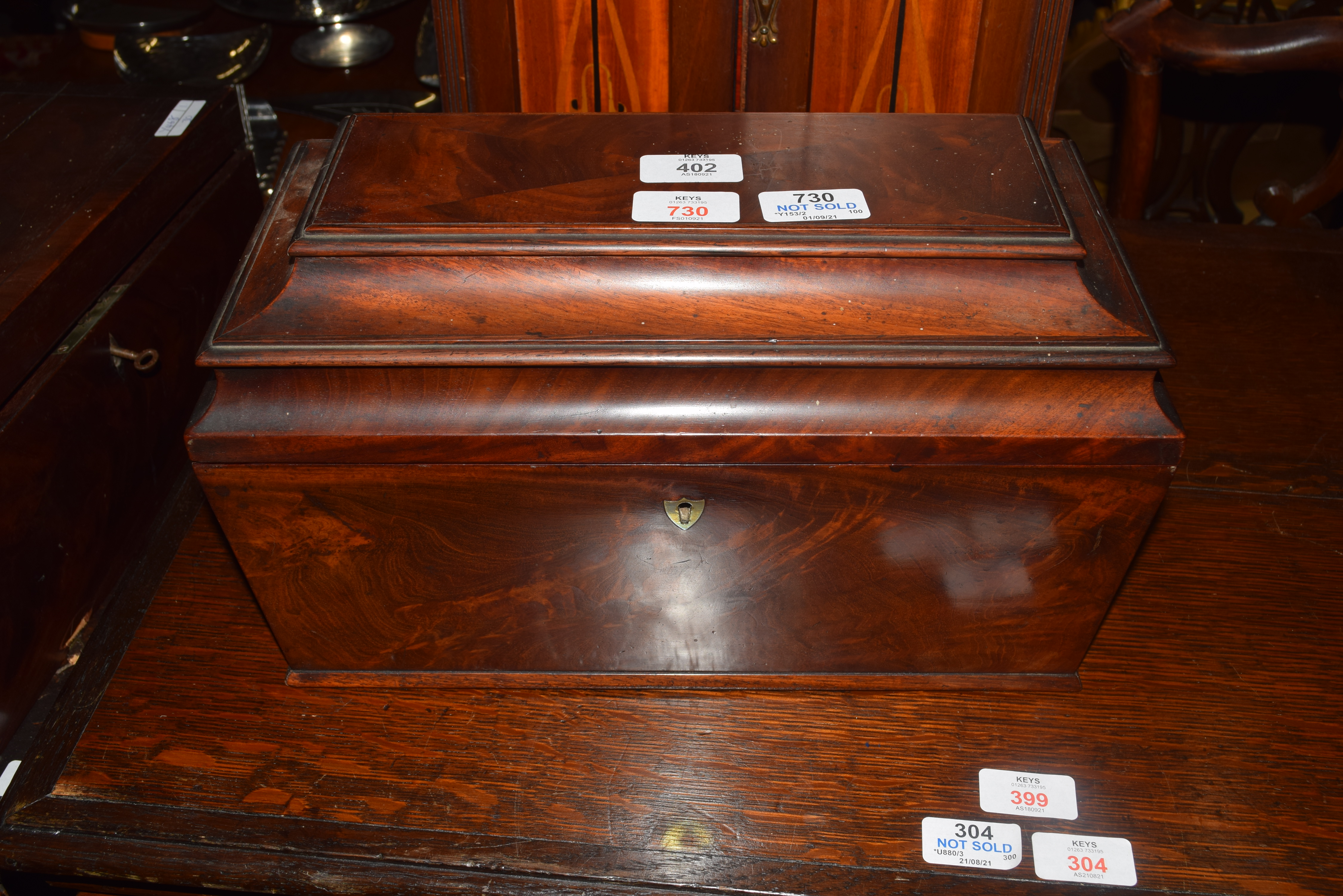 Georgian mahogany sarcophagus formed tea caddy, the hinged lid opening to an interior with two