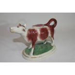 Pottery model of a cow creamer on oval base