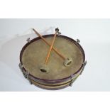 Small circular drum with red stained wooden surround, 31cm wide, together with two drumsticks