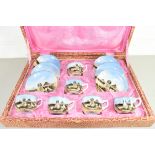 CASED PORCELAIN SET OF COFFEE CUPS AND SAUCERS DECORATED WITH EGYPTIAN PYRAMID SCENES