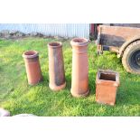 Three assorted terracotta chimney pots together with a further salt glazed drain attachment, largest