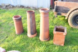 Three assorted terracotta chimney pots together with a further salt glazed drain attachment, largest