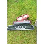 Jerry can and a Audi radiator cover, a further radiator cover and two vintage headlights