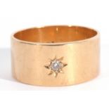 18ct gold and diamond set wide band ring, the plain polished band with a small diamond in a star