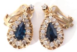 Pair of diamond and blue stone drop earrings, the pear shaped blue stones within a diamond