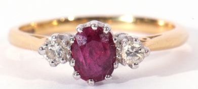 18ct gold ruby and diamond three stone ring, the oval faceted ruby 6 x 4mm, flanked by two small