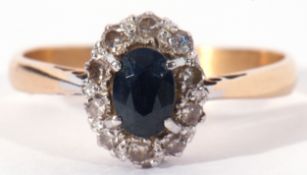 Sapphire and diamond cluster ring, the oval faceted sapphire within a small diamond surround, size
