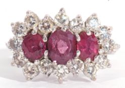 Ruby and diamond cluster ring, a design featuring three graduated oval shaped rubies, surrounded