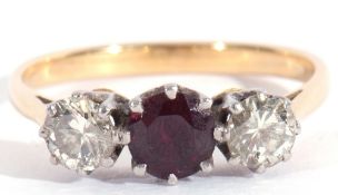 Ruby and diamond three-stone ring, the round faceted ruby flanked by two round brilliant cut