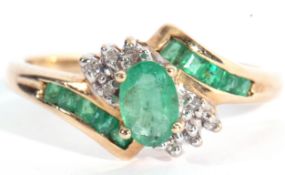 Modern 10K stamped diamond and synthetic emerald cluster ring, centring an oval faceted stone