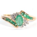 Modern 10K stamped diamond and synthetic emerald cluster ring, centring an oval faceted stone