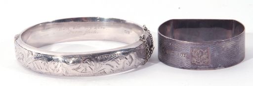 A hallmarked silver hinged bracelet, together with a silver D shaped napkin ring