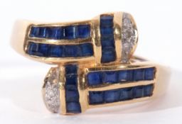 750 stamped sapphire and diamond cross over ring, each arm set with a square cut calibre cut