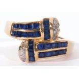 750 stamped sapphire and diamond cross over ring, each arm set with a square cut calibre cut