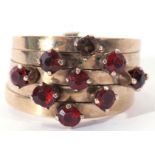 Modern 14K stamped five band stacking ring featuring 8 small garnets, (one missing), 4.5gms, size K