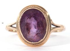 9ct gold amethyst ring, the oval shaped faceted amethyst bezel set and raised between split