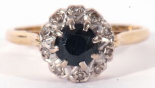 Sapphire and diamond cluster ring, the round shaped sapphire within a small single cut diamond