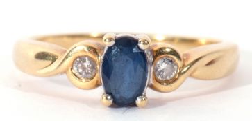 Modern sapphire and diamond ring centring an oval faceted sapphire raised between two small diamonds