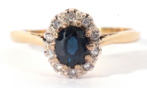 18ct stamped sapphire and diamond cluster ring, the oval central sapphire 6 x 4mm, within a small