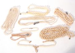 A blue bag containing various simulated pearl necklaces
