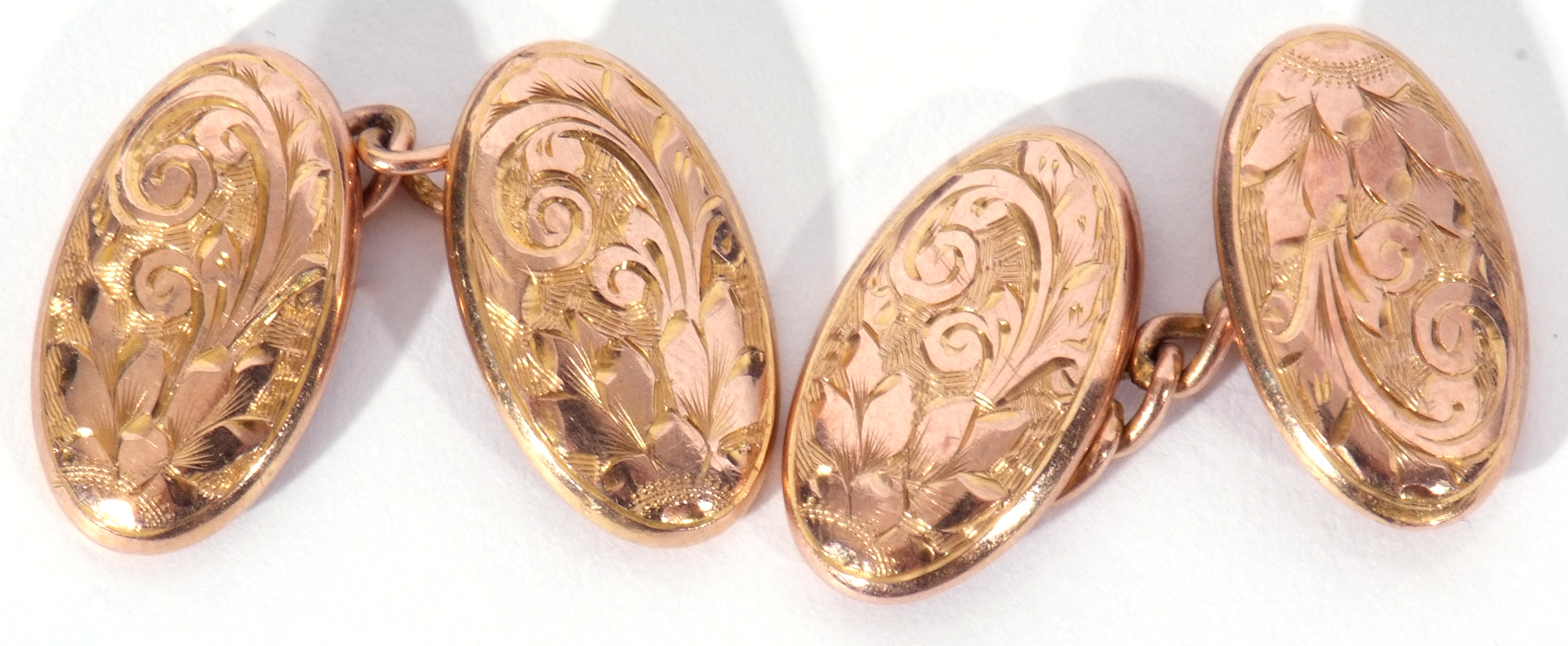 Pair of 9ct gold cuff links, the oval engraved panels chased and engraved with foliate and