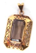 Yellow metal and smoky quartz pendant of rectangular cut, 26 x 18mm, bezel set in a pierced mount,