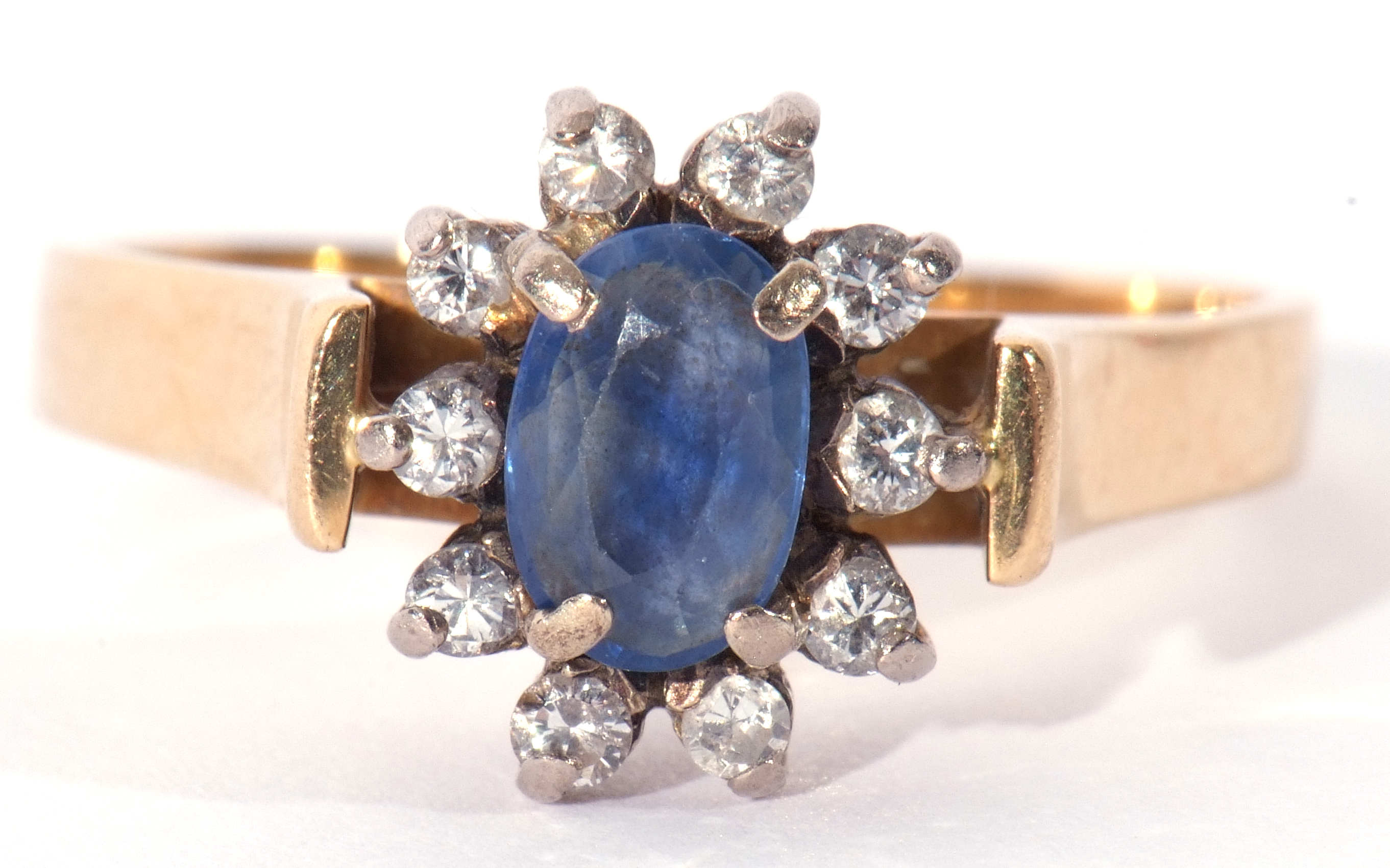 Sapphire and diamond ring, the oval shaped sapphire within a small brilliant cut diamond surround (