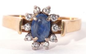 Sapphire and diamond ring, the oval shaped sapphire within a small brilliant cut diamond surround (