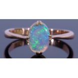 18ct stamped opal ring featuring an oval cabochon opal, cardinal set and raised between tapering