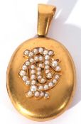 Victorian oval gold hinged locket, the front applied with a seed pearl decorated monogram, the verso