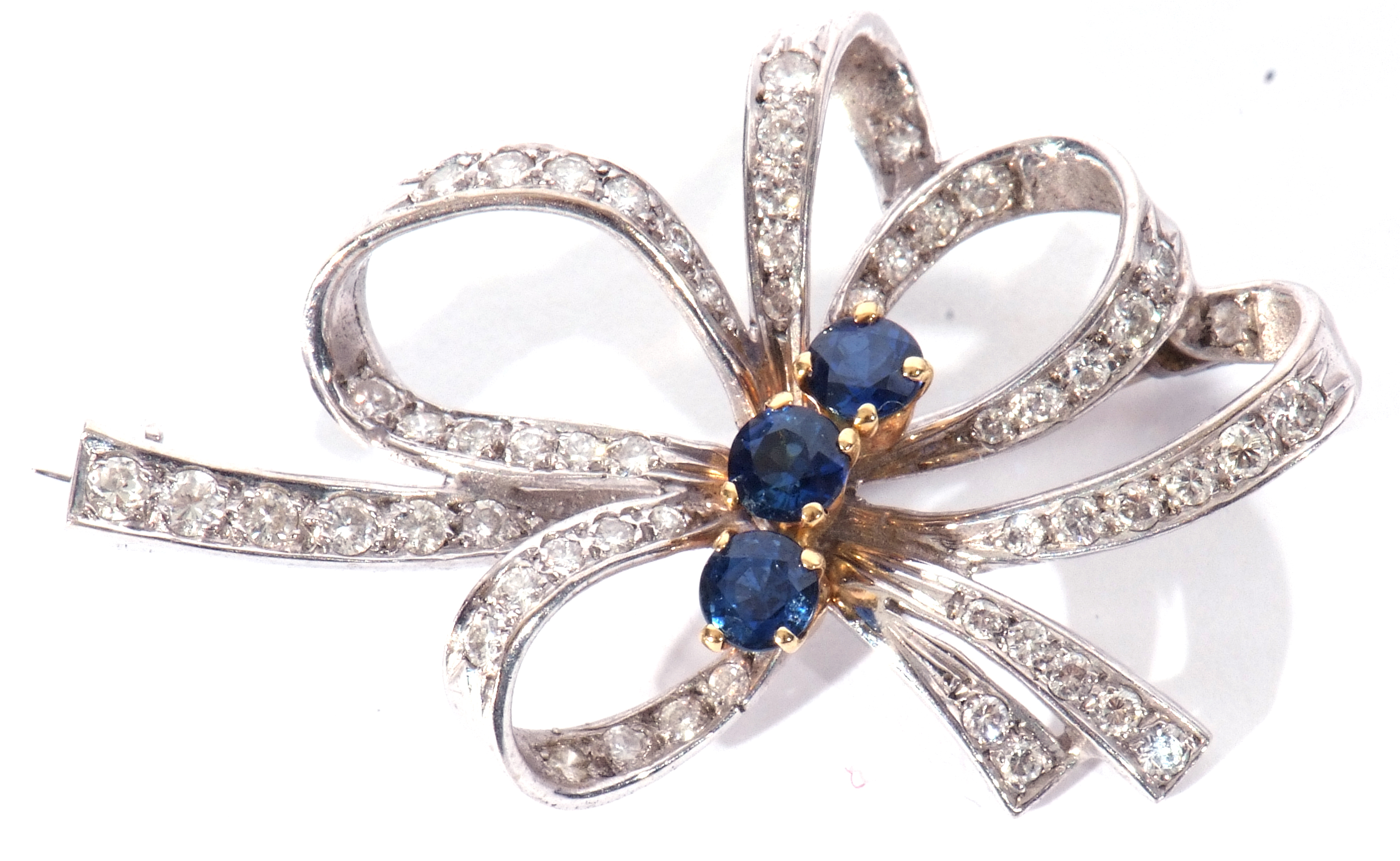 18ct white gold, sapphire and diamond brooch, a tied ribbon design centring three round cut small - Image 3 of 4