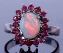 Modern opal and ruby cluster ring, the oval cabochon opal 8 x 6mm set within a small round ruby