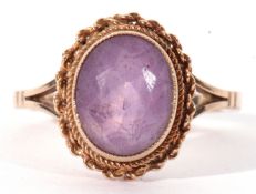 A 9ct gold and amethyst ring, the oval faceted amethyst bezel set within a rope twist frame, with
