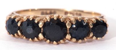 Modern 9ct gold sapphire five stone ring featuring five graduated round cut dark sapphires,