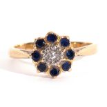 Sapphire and diamond cluster ring centring a small single cut diamond within a surround of eight