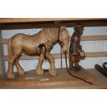 A CARVED WOODEN MODEL OF A FIGURE LEADING A HORSE, INITIALLED AW TO BASE