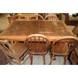 20TH CENTURY OAK DRAW LEAF DINING TABLE TOGETHER WITH A SET OF SIX STICK BACK CHAIRS AND A FURTHER