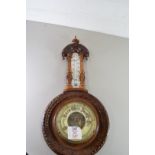 LATE VICTORIAN ANEROID BAROMETER AND THERMOMETER COMBINATION SET IN A CARVED HARDWOOD FRAME