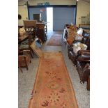 TWO PATTERNED WOOL FLOOR RUNNERS DECORATED WITH GEOMETRIC DETAIL AND FLOWERS ON A RED BACKGROUND,