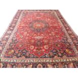 Large red ground Persian Mashad Carpet, mutlicoloured with traditional design 388cm x 270cm approx