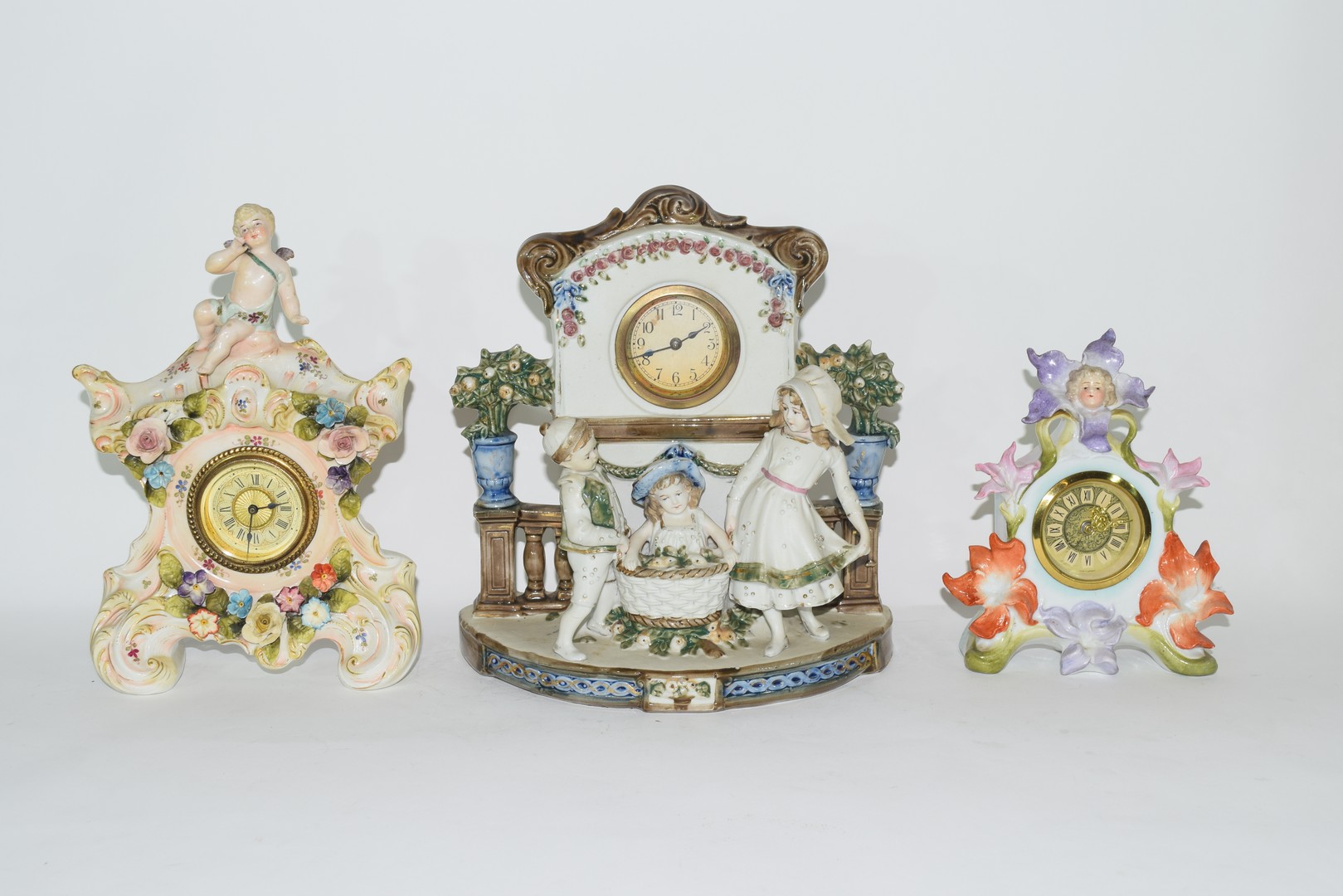 Three examples of Continental porcelain clock mantel cases